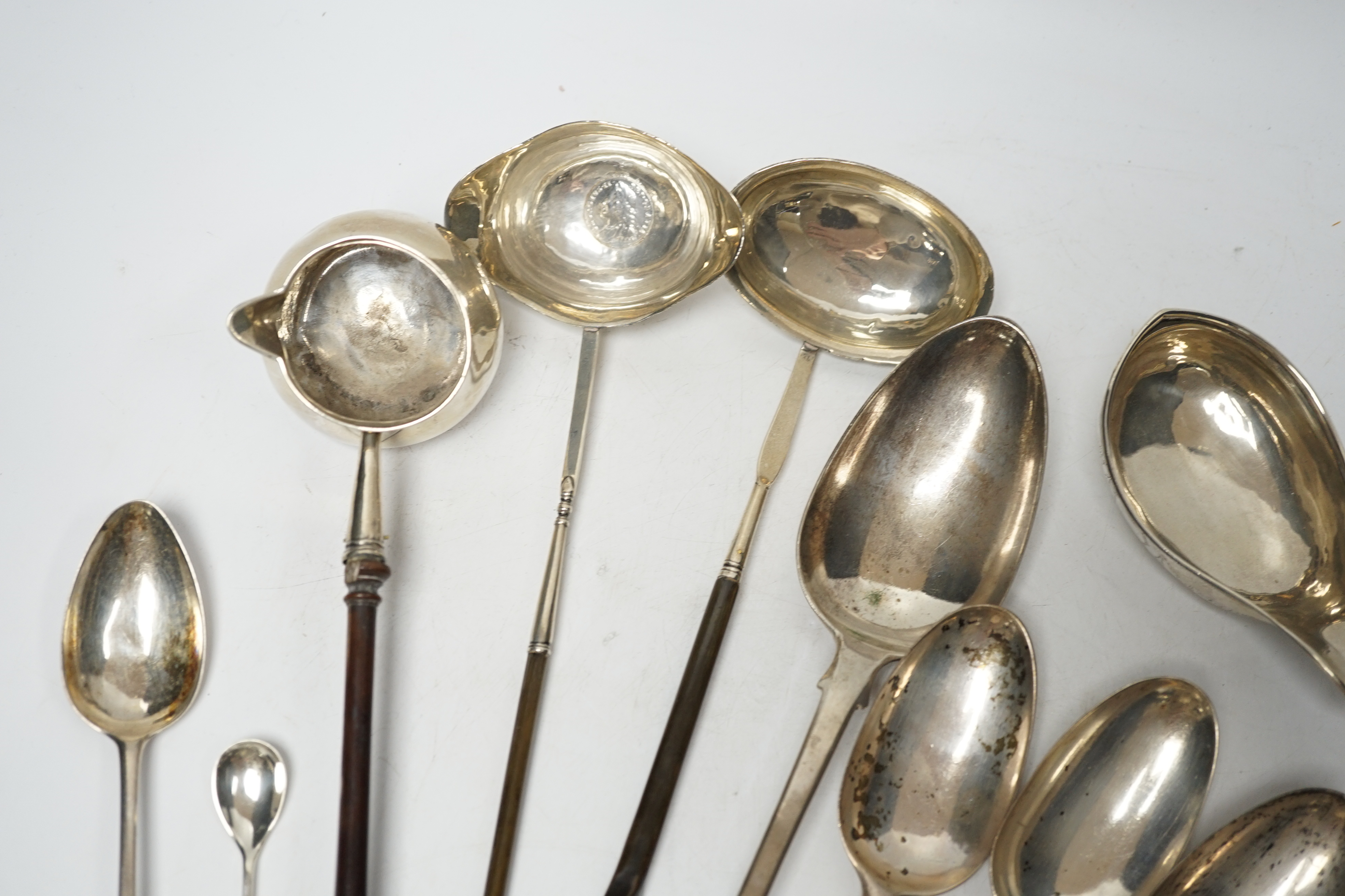 A late William IV silver fiddle pattern basting spoon, London, 1836, seven assorted 19th century silver base mark spoons, a Georgian Scottish dessert spoon, two toddy ladles, A George II brandy ladle, London, 1735, a Geo